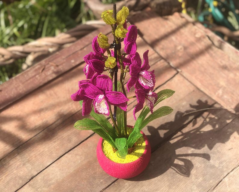 Orchidée en perles magenta dans un pot rose, art floral fait main