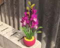 Orchidée en perles magenta dans un pot rose, art floral fait main