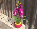 Orchidée en perles magenta dans un pot rose, art floral fait main