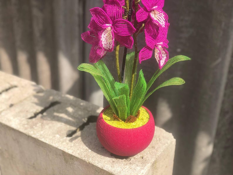 Orchidée en perles magenta dans un pot rose, art floral fait main