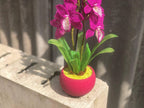 Orchidée en perles magenta dans un pot rose, art floral fait main