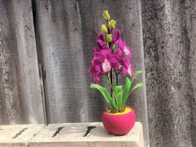 Orchidée en perles magenta dans un pot rose, art floral fait main