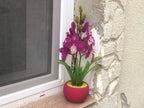 Orchidée en perles magenta dans un pot rose, art floral fait main