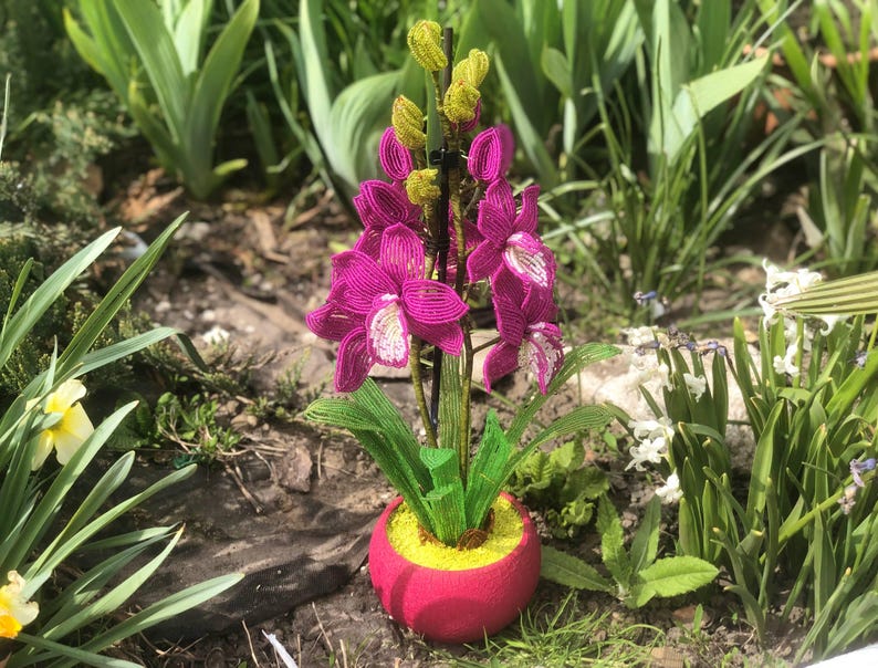 Orchidée en perles magenta dans un pot rose, art floral fait main