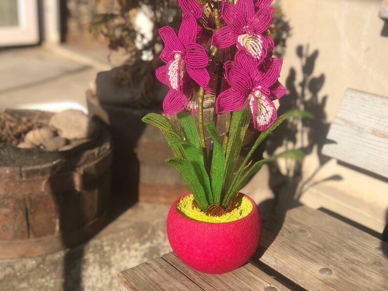 Orchidée en perles magenta dans un pot rose, art floral fait main