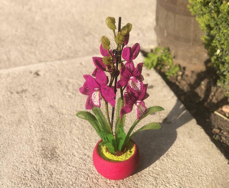 Orchidée en perles magenta dans un pot rose, art floral fait main